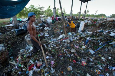 BALI, INDONESIA  APRIL 11: Poor from Java island working in a scavenging at the dump on April 11, 2012 on Bali, Indonesia. Bali daily produced 10,000 cubic meters of waste.